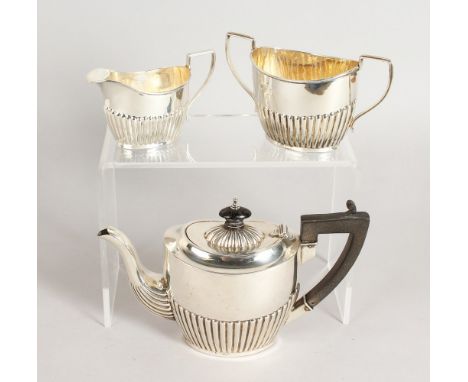 A SMALL SEMI FLUTED TEA SET, comprising teapot, sugar basin and milk jug. Birmingham 1898.