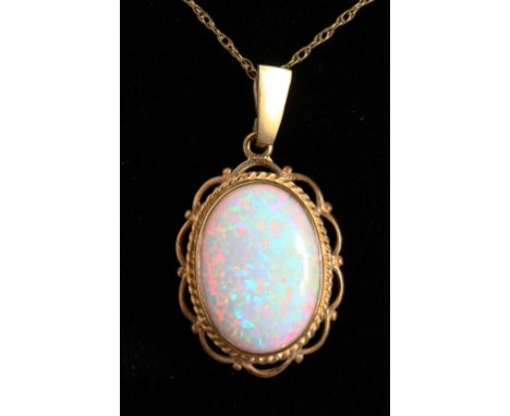 A 9CT GOLD OVAL OPAL PENDANT AND CHAIN.