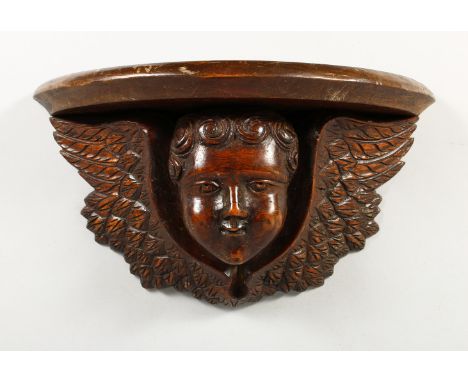 A 19TH CENTURY CHERUB WALL BRACKET. 13.5ins wide.