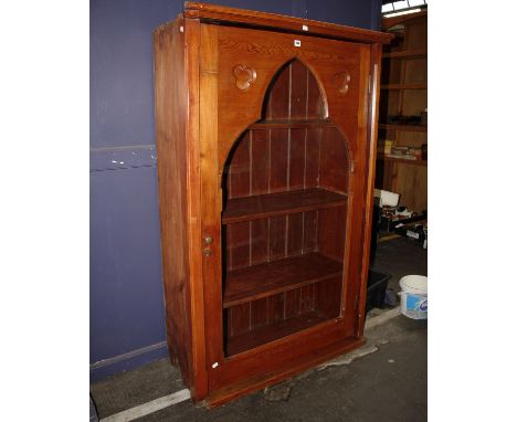 An arts and crafts style glass fronted bookcase. Arched single glass panel door in the ecclesiastic style. 101cm(W). 155cm(H)