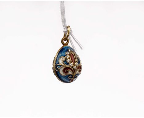 A yellow metal enamel and paste egg pendant. 