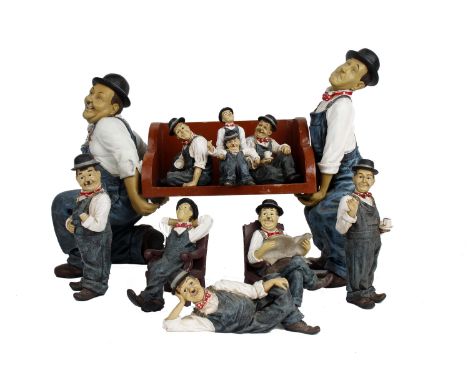 A collection of Laurel and Hardy ceramic figures, with wooden book support. 
