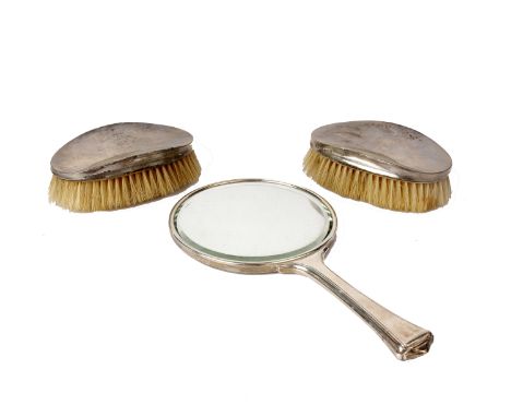 A sterling silver dressing table set. Hand mirror and two brushes with engine turned decoration. 