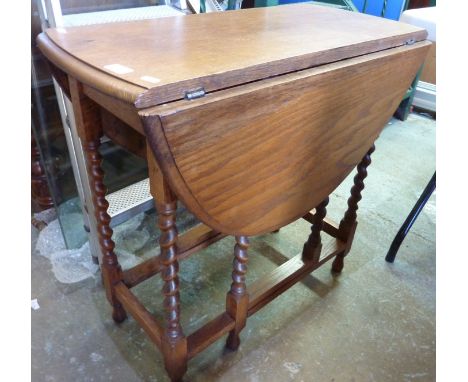 Light oak drop leaf table on barley twist supports 