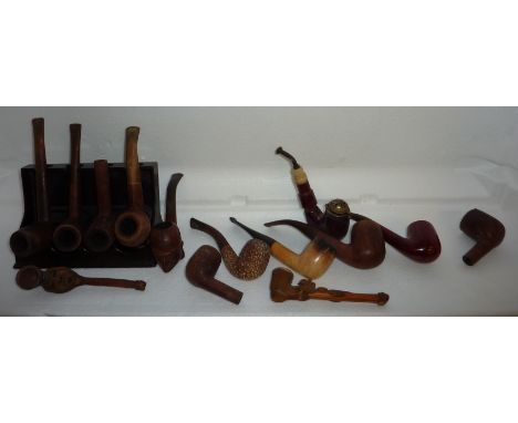 Pipe rack and assorted pipes including the Tyrolean carved wooden pipe in the form of a jockey, a plumb Meerschaum pipe etc
