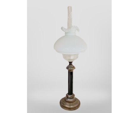An oil lamp with opaque glass shade, height 79cm. 