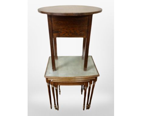 A nest of three tables with tool leather inset tops and a further oak oval table 
