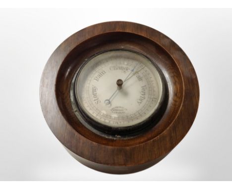 A circular barometer with silvered dial, diameter 22cm.