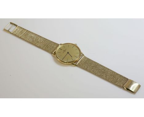 A gentlemen's 18ct gold Baume et Mercier Genève mechanical strap watch,on a later 9ct gold bracelet.  A circular champagne te