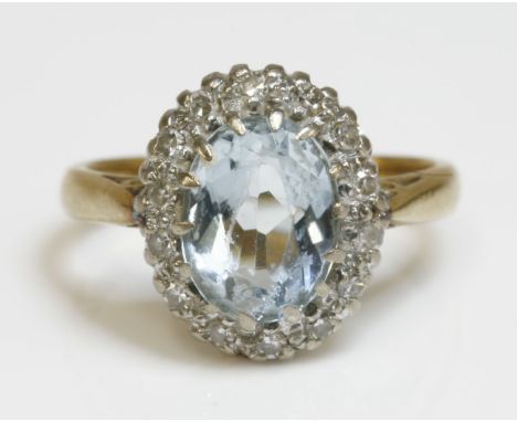 An aquamarine and diamond oval cluster ring,with a central oval mixed cut aquamarine, surrounded by eight cut diamonds.  Whit