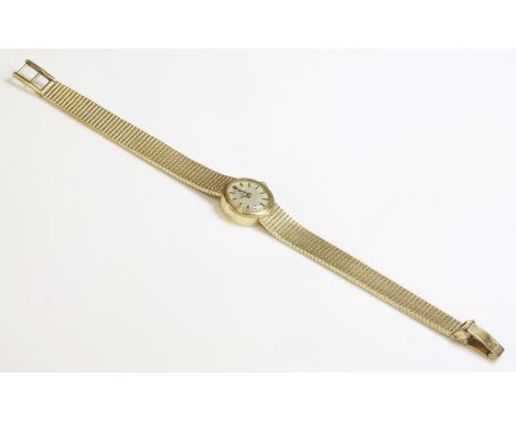 A ladies' 9ct gold Omega mechanical bracelet watch,with a circular silvered dial and raised gilt and black batons.  Integral 