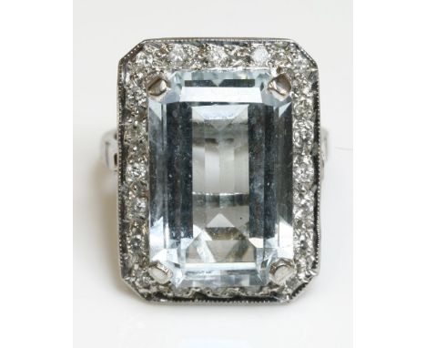 An 18ct white gold, aquamarine and diamond cluster ring,by A A Bond & Sons Ltd.  The rectangular step cut aquamarine, four cl