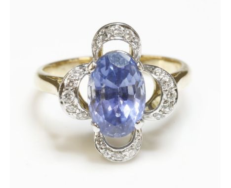 A sapphire and diamond quatrefoil cluster ring,with an oval mixed cut sapphire, four claw set to the centre.  Open quatrefoil