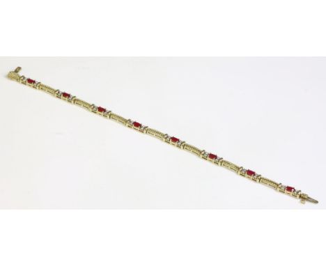 A 14ct gold, ruby and diamond line bracelet,with a series of oval mixed cut rubies, each one four claw set in a yellow collet
