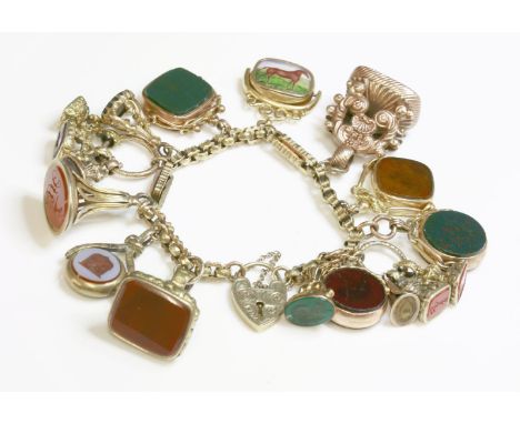 A gold charm bracelet,with faceted belcher links between scalloped box links with diaper decoration.  Seventeen assorted gold