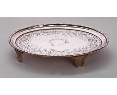 A George III Irish silver teapot stand,by Richard Sawyer, Dublin 1804, of oval form with foliate scroll frieze around a centr