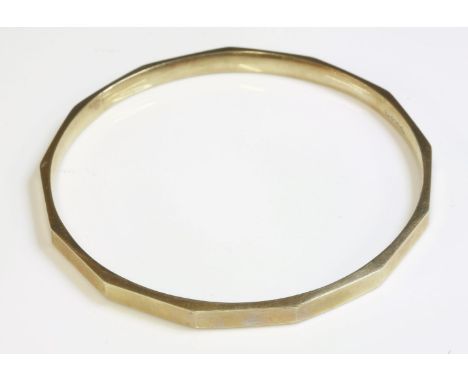 An Art Deco hollow gold slave bangle,with a series of flat section plain faces.  Marked 9ct