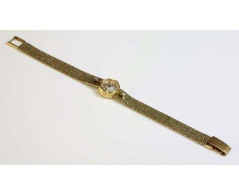 A ladies' two colour gold, diamond set Omega mechanical bracelet watch,a circular silvered raised baton dial with gold hands 