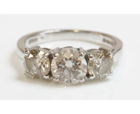 An 18ct white gold three stone diamond ring,with three graduated brilliant cut diamonds, all four claw set to plain collets, 