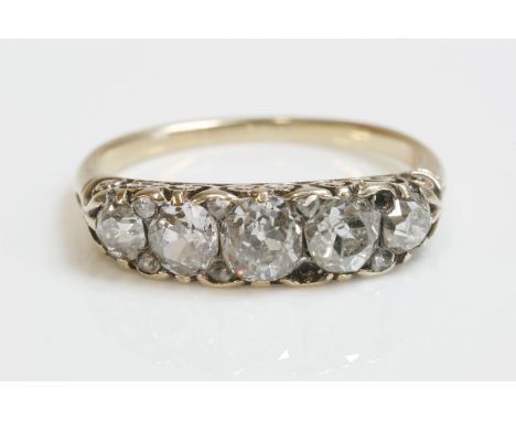 A late Victorian five stone diamond carved head ring with diamond set points,five graduated cushion cut and old European cut 