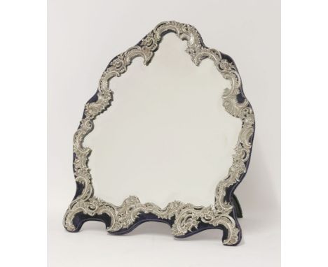 A Victorian silver mounted dressing table mirror, by William Comyns, London 1898,of cartouche shape with flower head and scro