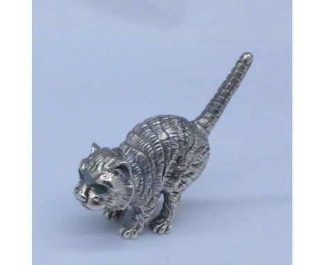A miniature sterling silver cat with green stone eyes