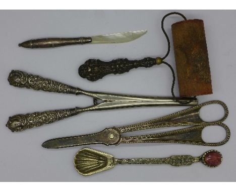 A silver and mother of pearl letter opener, a pair of silver handled glove stretchers, a silver handled roller, scissors and 