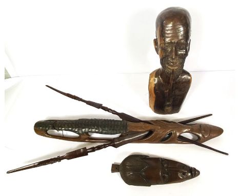 An African carved bust of a man smoking a pipe, hardwood, mid 20th century, 50cm high; together with a Tribal carved spear ho