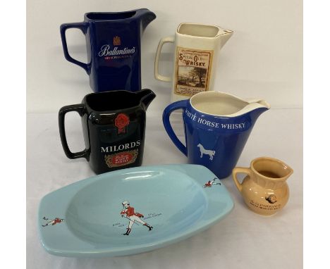 A collection of ceramic whiskey advertising water jugs together with an ashtray.  To include Wade ceramics. 