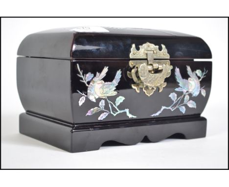 A 20th century Chinese papier mache jewellery box. Decorated with mother of pearl inlaid of Cranes, brass hinges and laok. Me