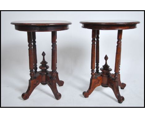 A pair of Victorian style hardwood circular lamp tables. Each raised on turned legs with finial united stretchers under circu