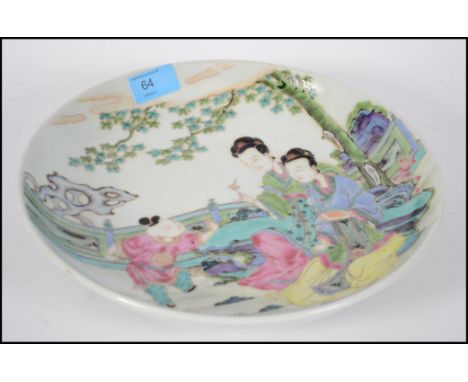 An early 19th Century large Chinese Famille bowl depicting two ladies playing with a young boy. Measures: 29cms wide. 
