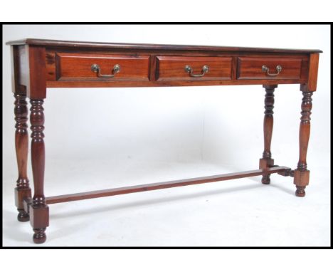 A good quality Victorian style large hardwood console hall table raised on turned legs united by stretchers having wide top a