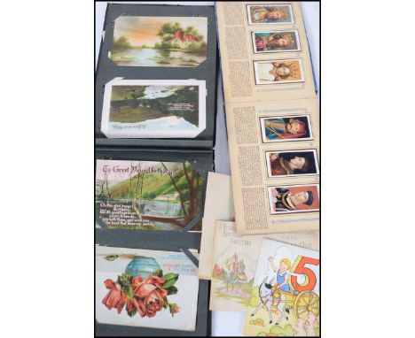 A vintage postcard album containing early 20th century verse postcards together with a cigarette card album by Players Kings 
