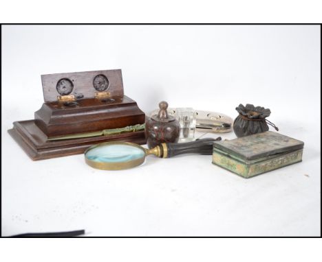 A 20th century desk top magnifying glass together with an oak desk tidy - inkwell set, glass inkwells, silver travelling whit
