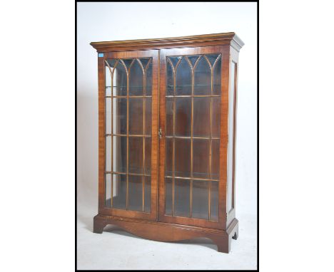 A Regency revival Bevan - Funnell Reprodux flame mahogany display cabinet, having twin astragal glazed upper doors with adjus