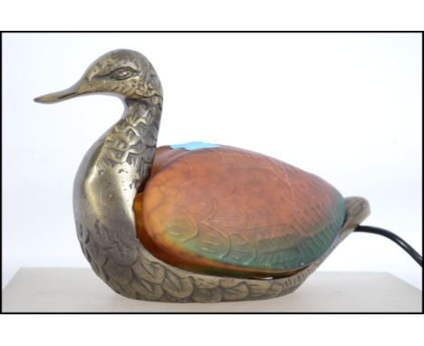 A 20th century table lamp in the form of a duck having a cast metal base with a Tiffany style glass shade. Measures 10cm long