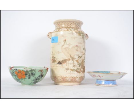 A group of three Oriental ceramic wares to include a tall vase painted with cranes and two painted bowls.  Measures: 22cms hi