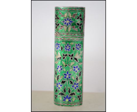 A Chinese silver and enamel adorned needle case. Enamel green ground on silver with blue and black foliates. Cylindrical ovoi