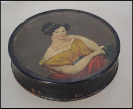 A 19th century papier mache patch box being ebonised with handpainted scene of a maiden. All of circular form. Measures:  9cm