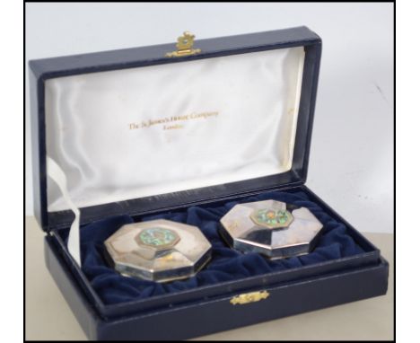 A pair of silver hallmarked pill boxes with enamel set tops and complete in the original presentation case by The St  James's