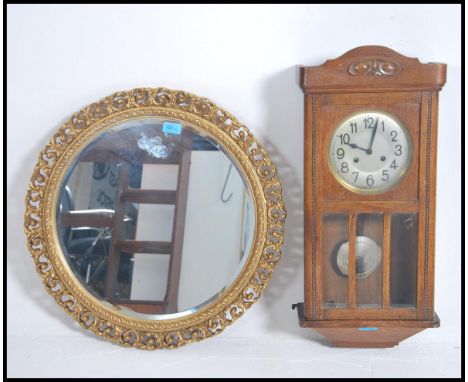 A vintage mid 20th century oak cased eight day wall clock together with a gilt framed mirror.