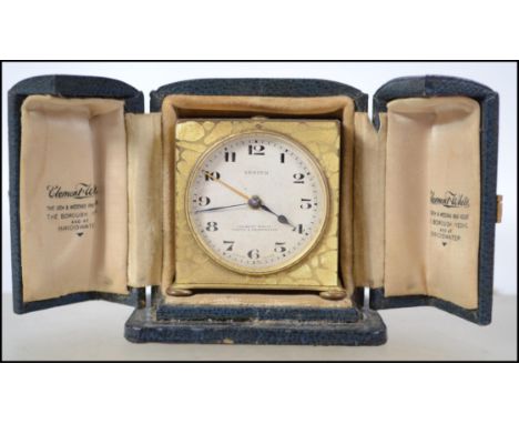 A early 20th century brass Zenith travel alarm clock, keyless wind movement striking on a bell, the silvered and gilt dial wi