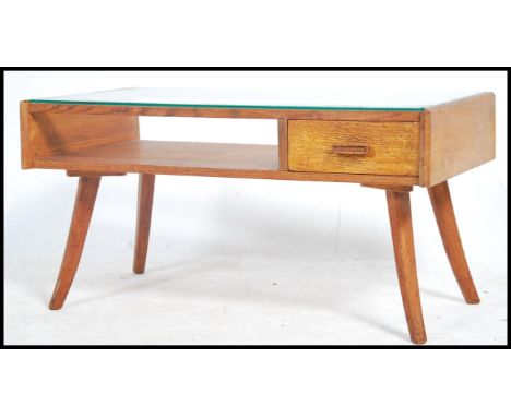 A 1950's / mid century retro oak coffee occasional table being made of solid oak with half section glass top over shelf with 