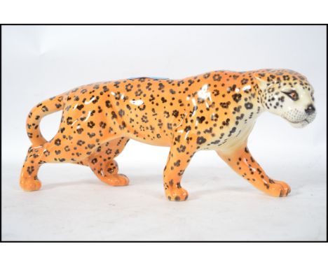 A large ceramic figurine by Beswick of a Leopard in a prowling position being stamped to the underside for Beswick England