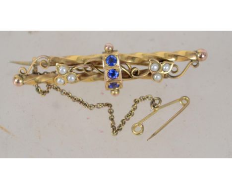 An Edwardian 9ct gold blue stone and pearl brooch with filigree scroll decoration having a c clasp with safety chain. Marked 