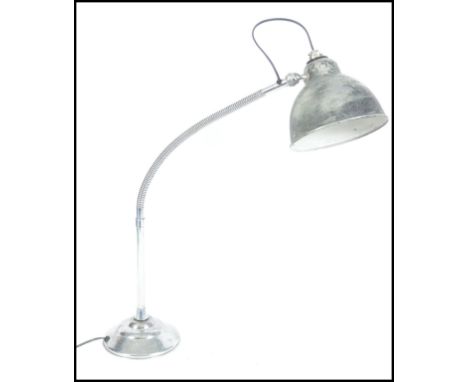 A vintage mid century retro industrial work lamp.  This goose neck light has a heavy metal weighted base and a chromed finish