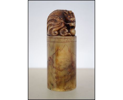 A Chinese soapstone wax seal of cylindrical form adorned with temple dog atop. The base with character marks and to the sides