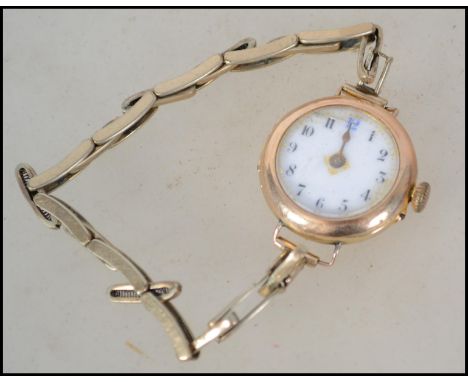 A vintage 20th century ladies 9ct gold ladies wrist watch having an enamel face on a filled gold bracelet.