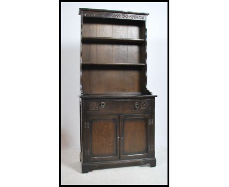 A 20th century Jacobean revival oak welsh dresser. Raised on bracket feet with cupboards and drawers under gallery plate rack